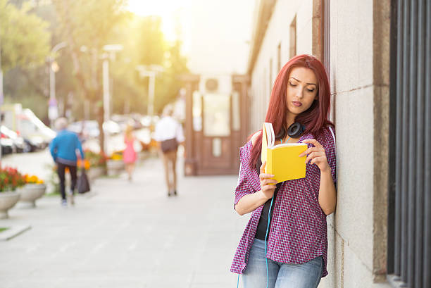 istock Teenage girl reading a book 623920892