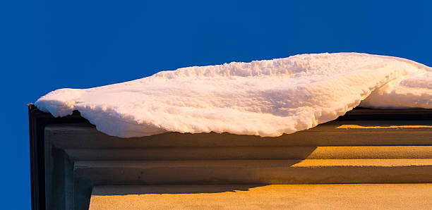 Snow on Edge of Roof with a clear blue sky.