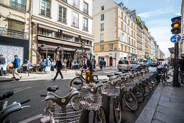 paris street with bicycles parked and people in a cafe - editorial horizontal cycling crowd imagens e fotografias de stock