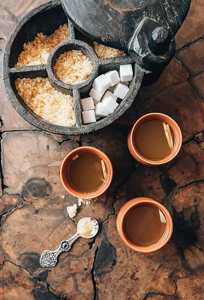 Three cups with ginger tea and rustic sugar-bowl on the wooden table