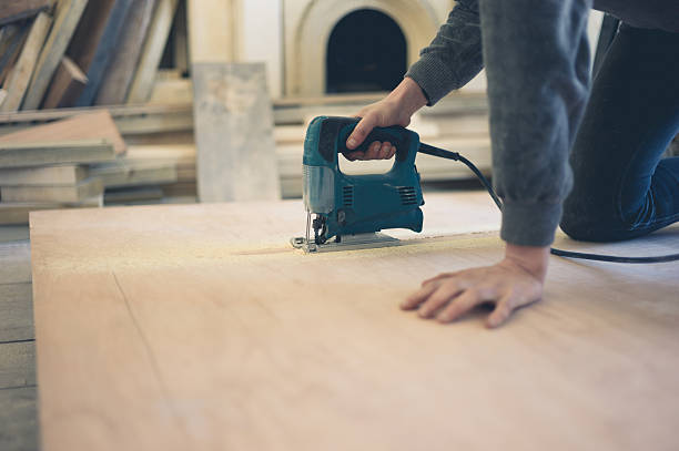 istock Young worker cutting wood with jigsaw 623928646