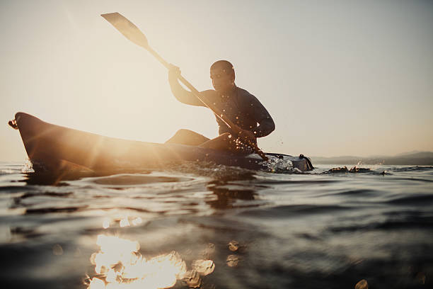 silueta de un piragüista - kayak barco de remos fotografías e imágenes de stock