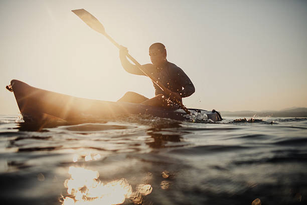 silhouette of a canoeist - canoeing imagens e fotografias de stock