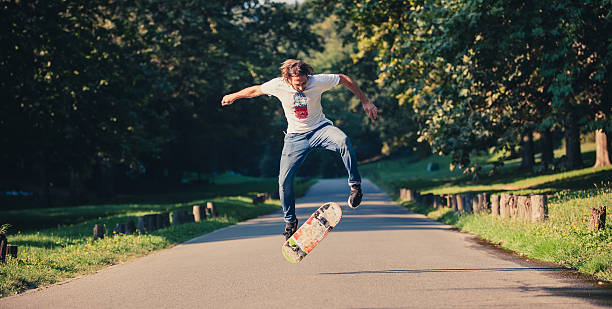 スケートボーダースケートのアクションショット、トリックをやってジャンプ - panoramic child scenics forest ストックフォトと画像