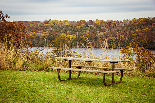 istock Park Bench Overlooking the River and Autumn Foliage 623931938