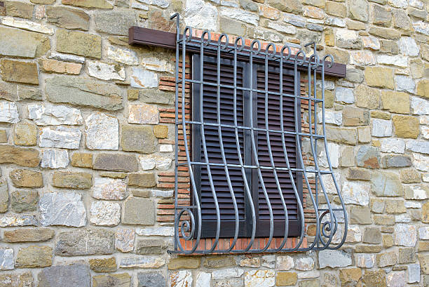 window window with iron grating on stone wall burglar bars stock pictures, royalty-free photos & images