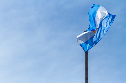 Flag of Argentina flaming against blue sky at Buenos Aires