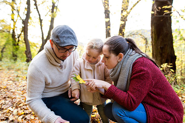 istock Beautiful young family on a walk in autumn forest. 623941762
