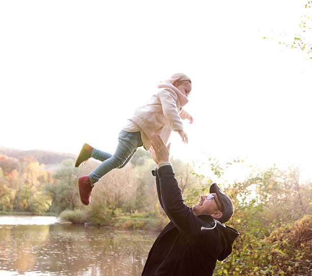 istock Father holding little daughter, throwing her in the air 623942746