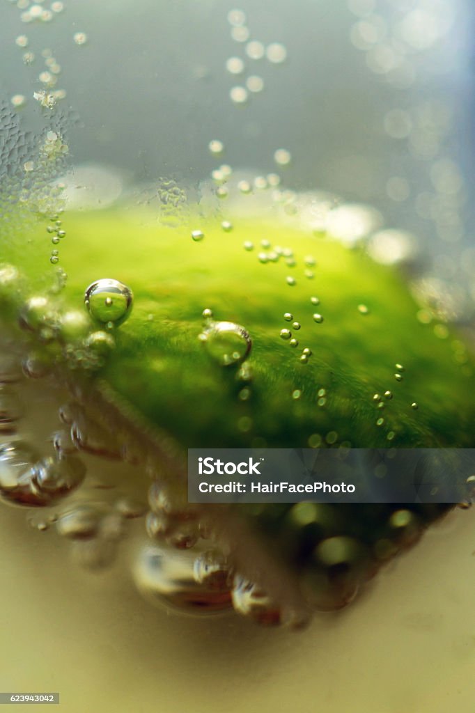 macro detail of bubbles coming off lime in beer macro detail of bubbles coming off of a lime wedge in a beer Alcohol - Drink Stock Photo