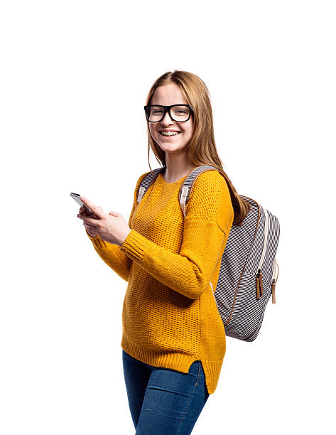 chica en suéter amarillo, sosteniendo el teléfono inteligente, tomando selfie, aislamiento - teenage girls cheerful smiling one person fotografías e imágenes de stock