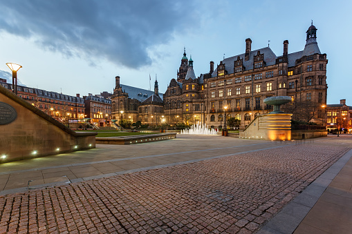 Leeds City Square at night. This is a large public square in the centre of the city. The main building shown is a former post office, now converted into several bars, restaurants and offices. Other offices and hotels surround the square.