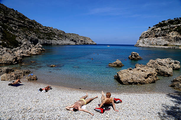 Rhodes, Greece - April 24, 2016 : Tourists sunbathe on the beach of Rhodes island.