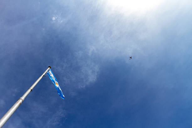 флаг аргентины пылает на фоне голубого неба и айплана - national flag flag global communications sky стоковые фото и изображения
