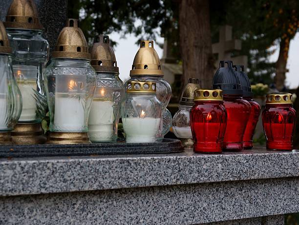 istock burning candels on tomb in cemetery 623968912