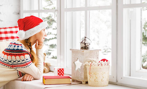 istock happy woman with  book in winter window 623969446