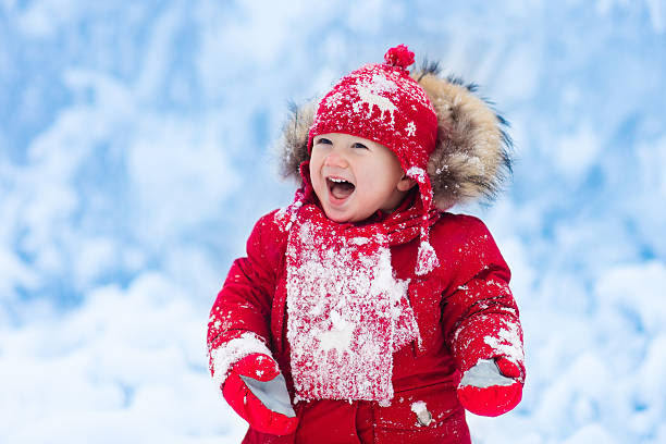 istock Baby catching snowflakes in winter forest 623971184