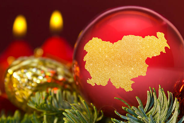 istock Red bauble with the golden shape of Slovenia.(series) 623982480