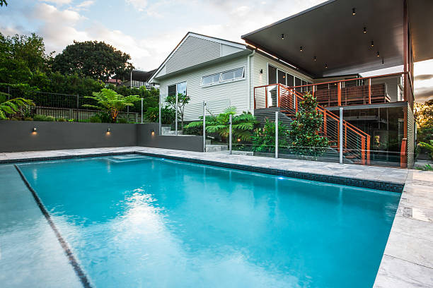 istock Modern pool with light blue water beside a mansion 623982790