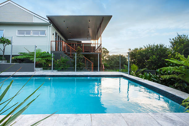 istock Modern swimming pool with blue water beside a house 623982862