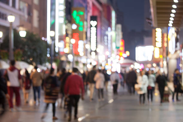 istock Blurred crowd in busy and brightly-lit shopping street at night 623982974