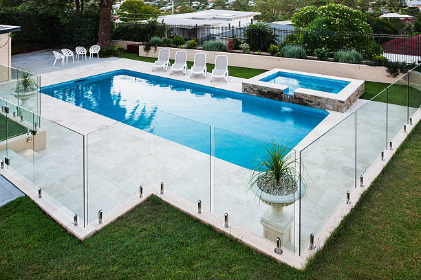 istock Modern swimming pool covered with glass panels beside a lawn 623983584