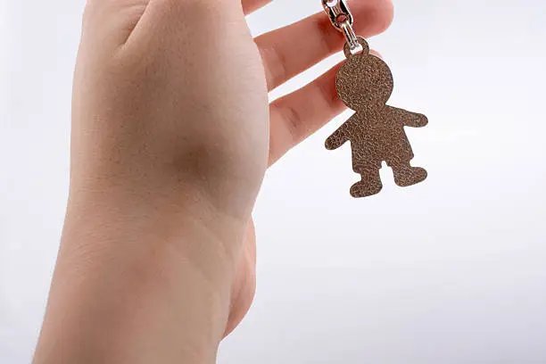 Man shaped keyholder in hand on white background