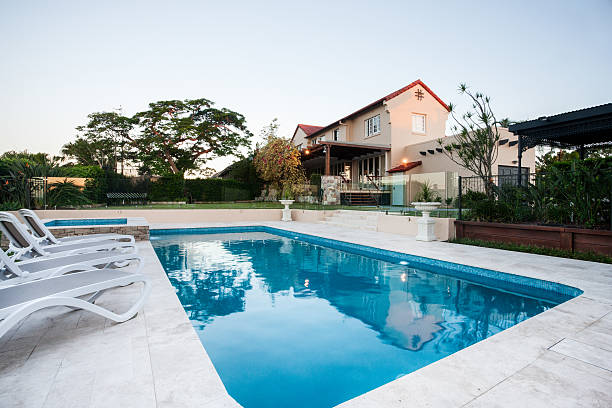 istock Swimming pool closeup next to chairs modern house garden 623983880
