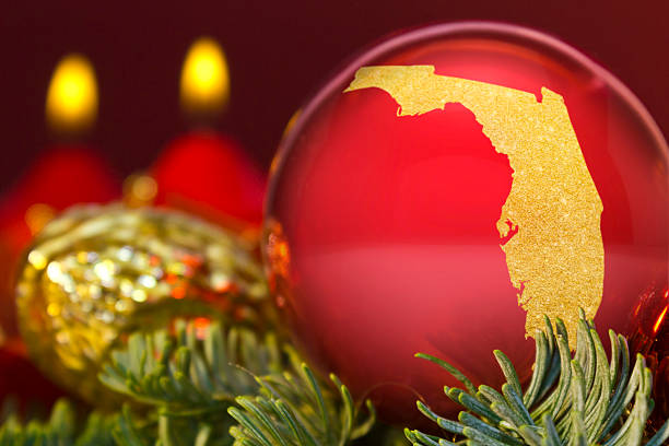 Red bauble with the golden shape of Florida.(series) A glossy red bauble with the golden shape of Florida.(series) florida christmas stock pictures, royalty-free photos & images