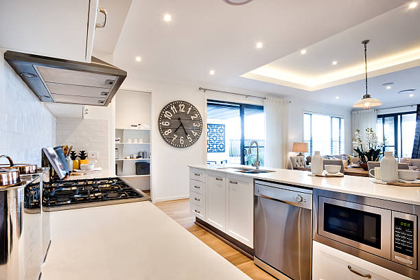 Modern kitchenware including a stove and ovens with big watch