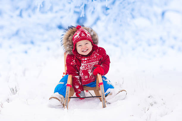маленькая девочка, наслаждаясь на санях - little boys sled clothing slide стоковые фото и изображения