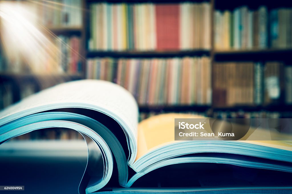 Piles of books and magazines on background of book shelf Article Stock Photo