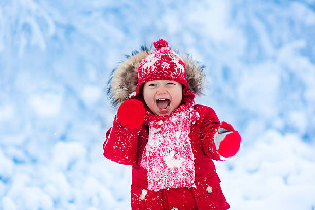 istock Little laughing baby playing with snow in winter. 624006526