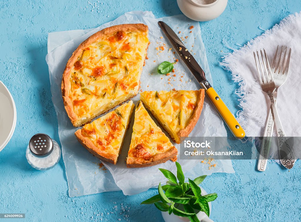 Leek, potato and cheese pie on a blue background Leek, potato and cheese pie on a blue background, top view. Quiche Stock Photo