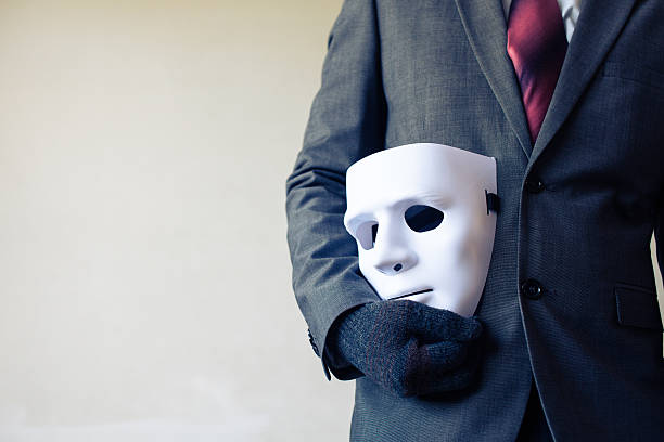 homme d’affaires portant un masque blanc - fraude commerciale et concept de falsification - accessoire de déguisement photos et images de collection