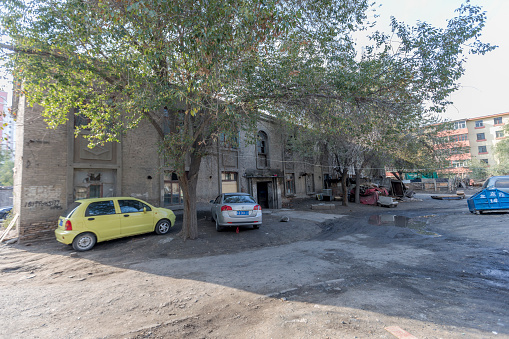 Urumqi, Xinjiang, China - October 4, 2016: Urumqi abandoned residential building outside view. A few cars parked at outside.
