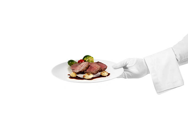 Serving meat dish detail of waiter serving a chic meat dish formal glove stock pictures, royalty-free photos & images