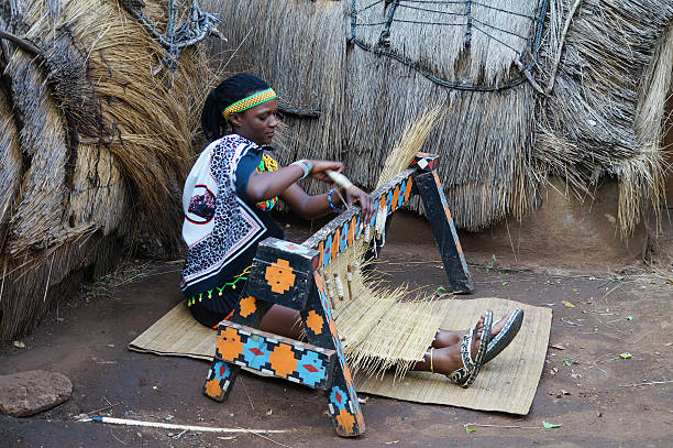 伝統的な手作りの衣装を着たアフリカのズールーの女性は、わらのカーペットを織ります。 - south africa africa women zulu ストックフォトと画像