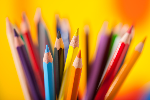 many colorful pencils with rainbow background