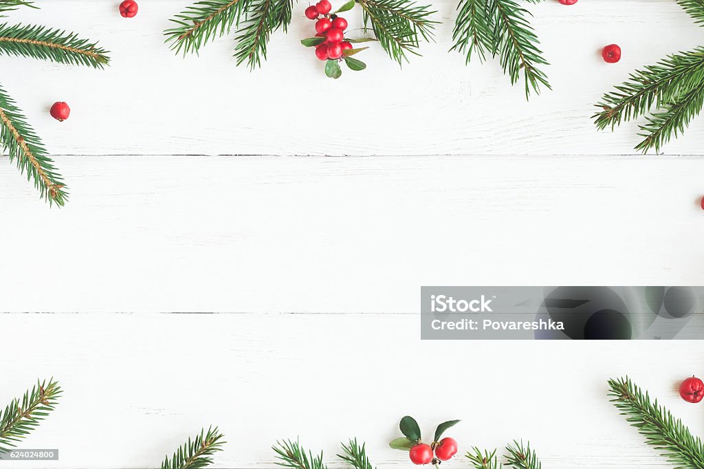 Christmas frame made of fir branches, red berries. Flat lay Christmas frame made of fir branches, red berries. Christmas wallpaper. Flat lay, top view Christmas Stock Photo