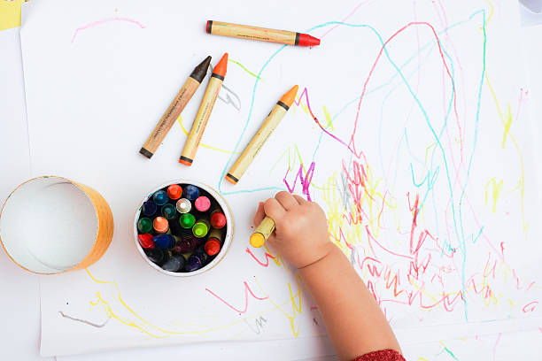 baby's hand drawing on the white paper with colorful crayons - color image photography crayon art imagens e fotografias de stock