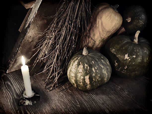 Dark mystic ritual with broom stick, candle and pumpkins by staircase.  Occult or esoteric concept with magic objects, Halloween background