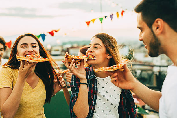 istock Eating pizza at a party on the roof 624028110