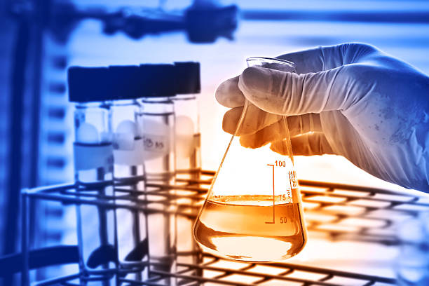Flask in scientist hand with laboratory background stock photo
