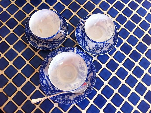 three blue china cups and saucers on a blue tile counter