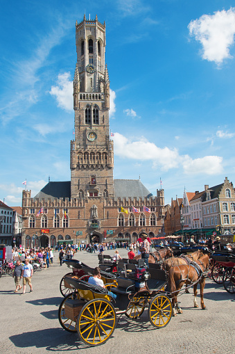 Bruges, Belgium - June 12, 2014: Bruges - The Carriage on the Grote Markt and Belfort van Brugge in background.