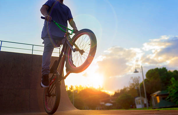 BMX bike rider jumping with bike on bicycle ramp BMX bike rider jumping with bike on bicycle ramp in sunny afternoon. bicycle stunts stock pictures, royalty-free photos & images