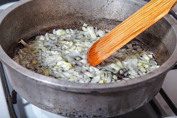 istock woman frying onions 624067014