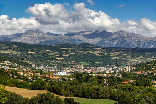 The city of Gap in the Hautes Alpes with surrounding mountains and peaks in Summer. Southern French Alps, France