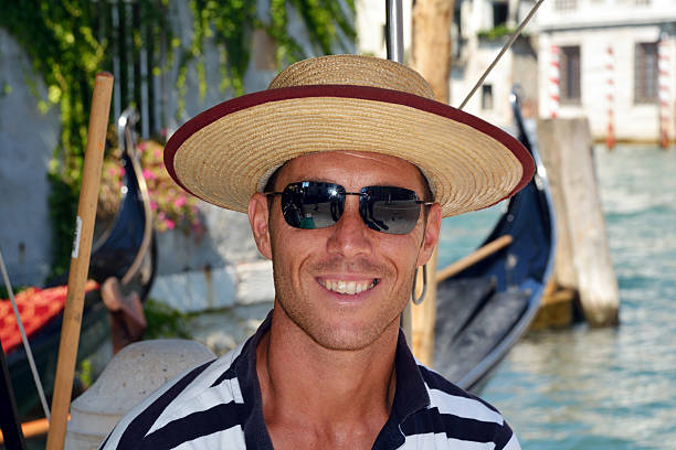 Venice, Veneto, Italy - September 8, 2016: Gondolier with the typical headgear on a canal of Venice in Italy.